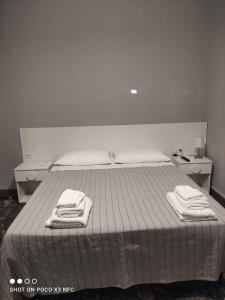 a bedroom with a bed with two towels on it at B&B Villa Fiorita in Marina di Camerota