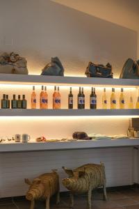two statues of sheep are on a shelf with bottles at Hotel Blaumar Cadaqués by Fimedhotels in Cadaqués