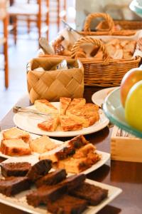 a table with three plates of food and a basket of apples at Hotel Blaumar Cadaqués by Fimedhotels in Cadaqués