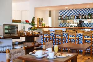 a restaurant with wooden tables and chairs and a counter at Hotel Blaumar Cadaqués by Fimedhotels in Cadaqués