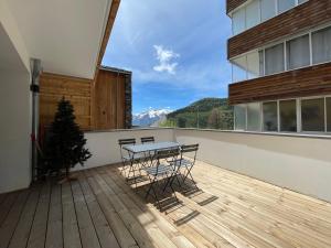 a balcony with a table and chairs on a deck at Homency - Résidence Fermes de l'Alpe D102 in L'Alpe-d'Huez