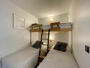 two bunk beds in a small room with white beds at Homency - Résidence Fermes de l'Alpe D102 in L'Alpe-d'Huez