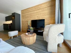 a living room with a chair and a television at Homency - Résidence Fermes de l'Alpe D102 in L'Alpe-d'Huez +8 photos