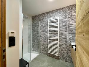 a bathroom with a shower with a glass door at Homency - Résidence Fermes de l'Alpe D102 in L'Alpe-d'Huez