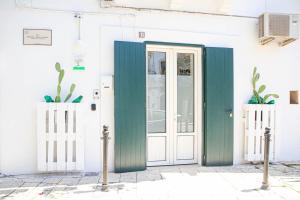 una puerta verde frente a un edificio blanco en La Vispa Teresa Almalusa Apulian home by In Puglia service, en Martina Franca