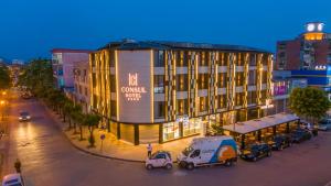 duży budynek z zaparkowanymi przed nim samochodami w obiekcie Hotel Consul w Szkodrze