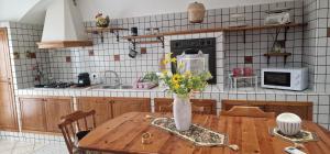 a kitchen with a table with a vase of flowers on it at MARY ROSE - Locazione Turistica in Brindisi