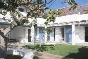 a large white house with a patio and trees at Hotel Intorno Al Fico in Fiumicino