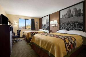 a hotel room with two beds and a television at Super 8 by Wyndham Cedar Rapids in Cedar Rapids
