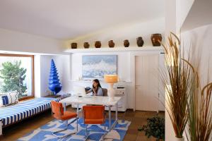 a woman sitting at a table in a room at Hotel Blaumar Cadaqués by Fimedhotels in Cadaqués