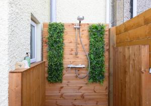 a wall with a shower with ivy on it at Aurora House Hot Tub & Sea View in Buckie +51 photos