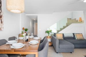 un soggiorno con un tavolo e un divano di MEDANO4YOU Tenerife Breeze a El Médano