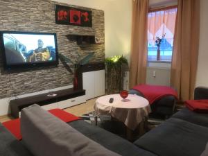 a living room with a couch and a tv on a brick wall at Monteurwohnung in Salzgitter