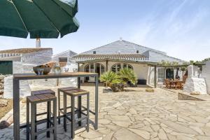 un patio con mesa y taburetes frente a una casa en Finca Son Sanxo, en Alaior