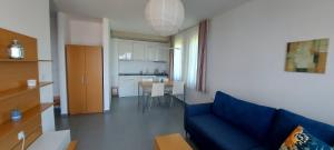 a living room with a blue couch and a kitchen at Sozopol Paradise view in Sozopol