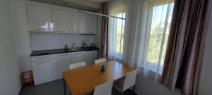 a kitchen with a wooden table and white cabinets at Sozopol Paradise view in Sozopol +12 photos