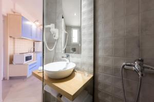 a bathroom with a sink and a glass shower at Karystos Mare Apartments in Karistos +86 photos