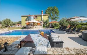basen z krzesłami oraz dom i budynek w obiekcie Nice Home In Galizana w mieście Galižana
