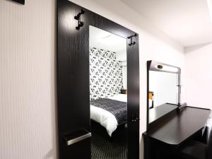 a mirror in a room with a bed and a bedroom at APA Hotel Ogaki Ekimae in Ogaki