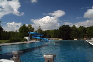 duży basen z niebieską zjeżdżalnią w obiekcie JUFA Hotel Weinviertel - Eselsmühle w mieście Seefeld