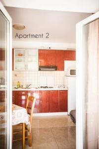 ロパールにあるApartment in Lopar with sea view, terrace, Wi-Fi, washing machine (186-2)のキッチン(木製キャビネット、テーブル、テーブル、椅子付) +27枚の写真