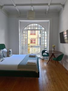 a bedroom with a bed and a table and a window at Casa D'Almeida by Porto Stories in Porto