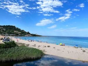 a beach with people on the sand and the water at Appartement T3 Vue mer in Conca