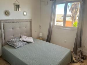 une chambre avec un lit avec un oreiller et une fenêtre dans l'établissement Appartement T3 Vue mer, à Conca