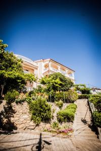 ein großes Gebäude mit einem Gehweg davor in der Unterkunft Apartment in Lopar with sea view, loggia, air conditioning, W-LAN (186-4) in Lopar