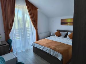 a bedroom with a bed and a large window at Pensiunea Anna in Poplaca +27 photos