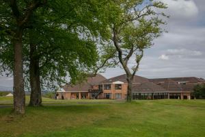a large house with trees in front of it at Doubletree By Hilton Glasgow Westerwood Spa & Golf Resort in Cumbernauld