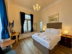 a bedroom with a large bed with towels on it at Vernon Guesthouse in Eastbourne