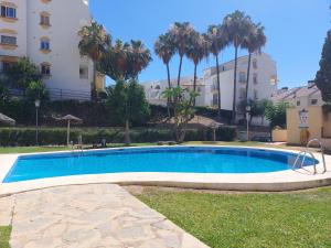 a swimming pool in front of a building at Estudio con Piscina y Parking, Playa a 4 Min a Pie, Tren a 2 Min in Fuengirola