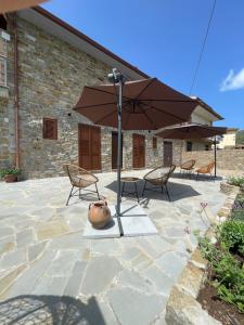 卡斯特拉巴特Casale Conti的带桌椅和遮阳伞的露台