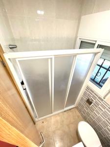 a bathroom with a toilet and a large window at Apartment Sanatori Beach, Barcelona in Calafell
