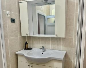 un bagno con un lavandino bianco e uno specchio di Tarihi Asansör Sokağında Daire a Smirne Altre 30 foto