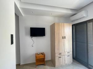 a room with a flat screen tv on a wall at Ntina's Room in Nea Potidaea
