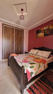 1 dormitorio con 1 cama grande y edredón colorido en Logement Sable et Vagues, en Saidia 