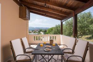 a table and chairs on a balcony with a view at Casa Magnolia in Katokhórion