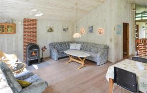 a living room with a couch and a table and a fireplace at Holiday Home Villesensvej Ii in Fjellerup