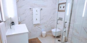 a white bathroom with a shower and a toilet at Holidays Nazaré Centro in Nazaré