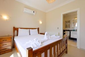 a bedroom with a large bed with white sheets at Villa Arokarya in Fethiye +48 photos