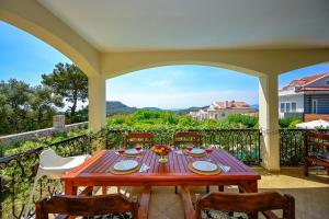 a wooden table with chairs on a patio at Villa Arokarya in Fethiye
