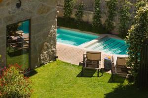 a backyard with a swimming pool and two chairs at Torel Saboaria in Porto