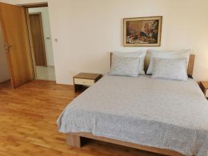 a bedroom with a bed and a painting on the wall at Apartment Kira - spacious apartment with sea view in Ližnjan