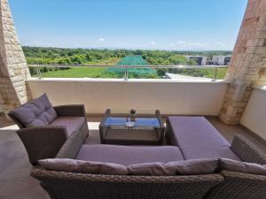 a patio with wicker chairs and a table on a balcony at Apartment Kira - spacious apartment with sea view in Ližnjan