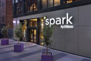 罗姆福特Spark by Hilton London Romford的一座火花建筑，前面有盆栽树