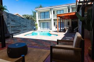 a backyard with a swimming pool and a house at Loft Bella Vita Guesthouse in Bloemfontein