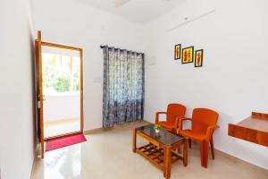 a room with two chairs and a table and a mirror at Galaxy Homestays in Malpe
