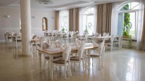 a dining room with white tables and white chairs at Hotel Sen in Świebodzin